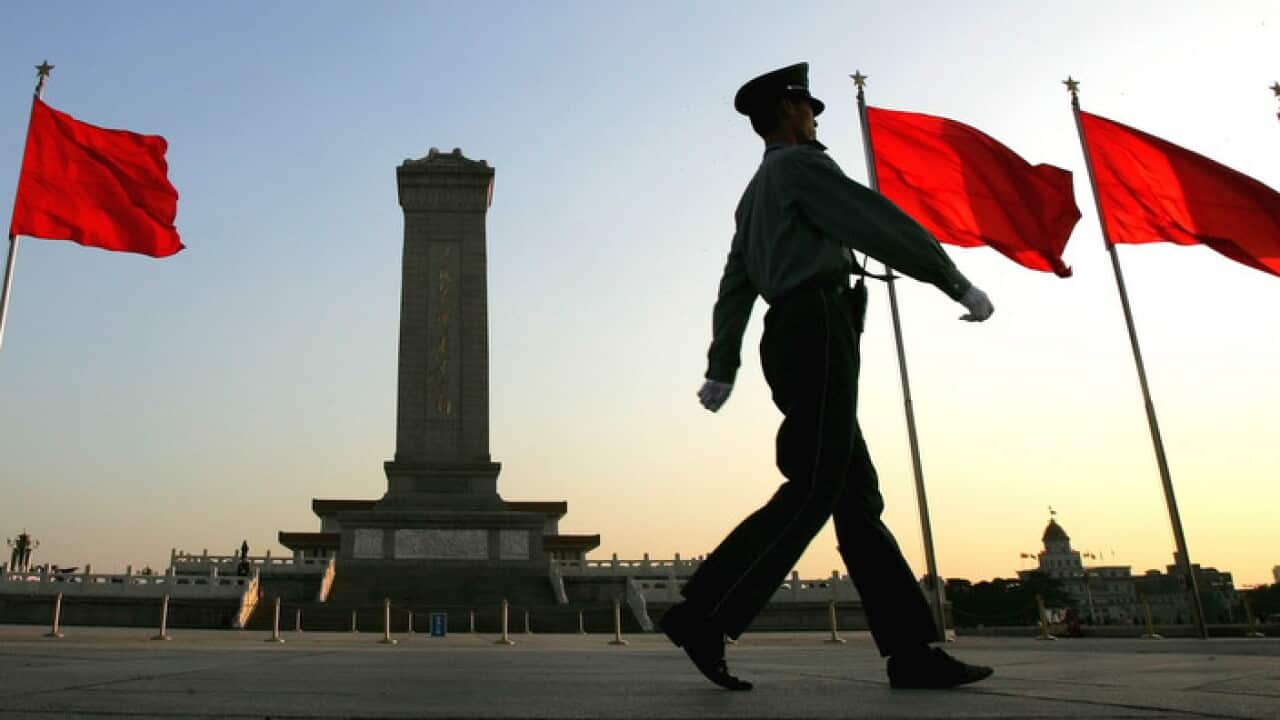 A security guard marches past flags decorating Beijing’s Tianenman Square