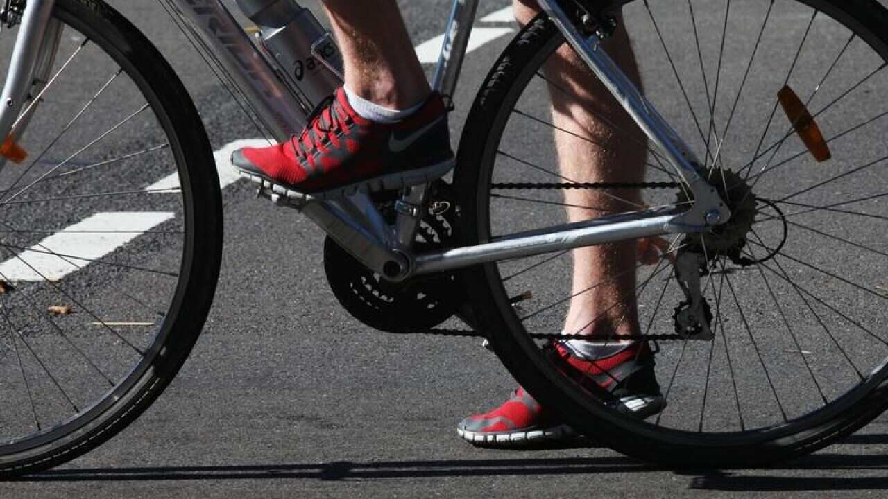 A cyclist waits in traffic