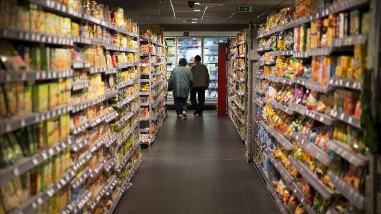 A couple walks in a supermarket food aisle in Paris, France. AFP PHOTO /JOEL SAGET (Photo credit should read JOEL SAGET/AFP/Getty Images)