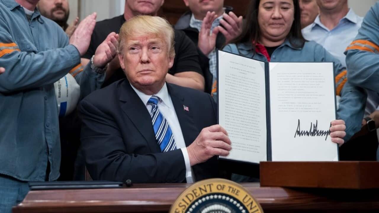 US President Donald J. Trump (C) signs a presidential proclamation on steel tariffs.