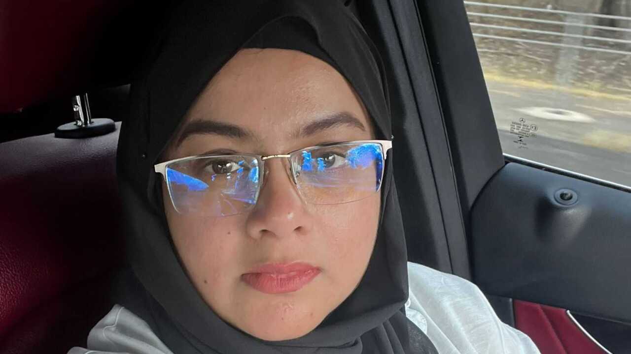 A woman in a headscarf looks at the camera