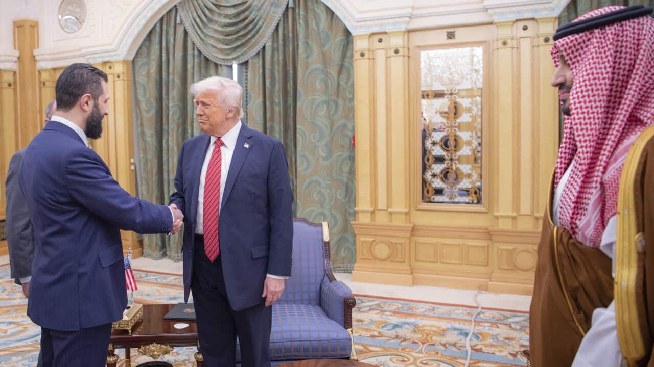 In this photo released by the Saudi Royal Palace, interim Syrian President Ahmad al-Sharaa (L) shakes hands with US President Donald Trump (R) in Riyadh, Saudi Arabia, Wednesday, May 14, 2025. On the right is Saudi Crown Prince Mohammed bin Salman.