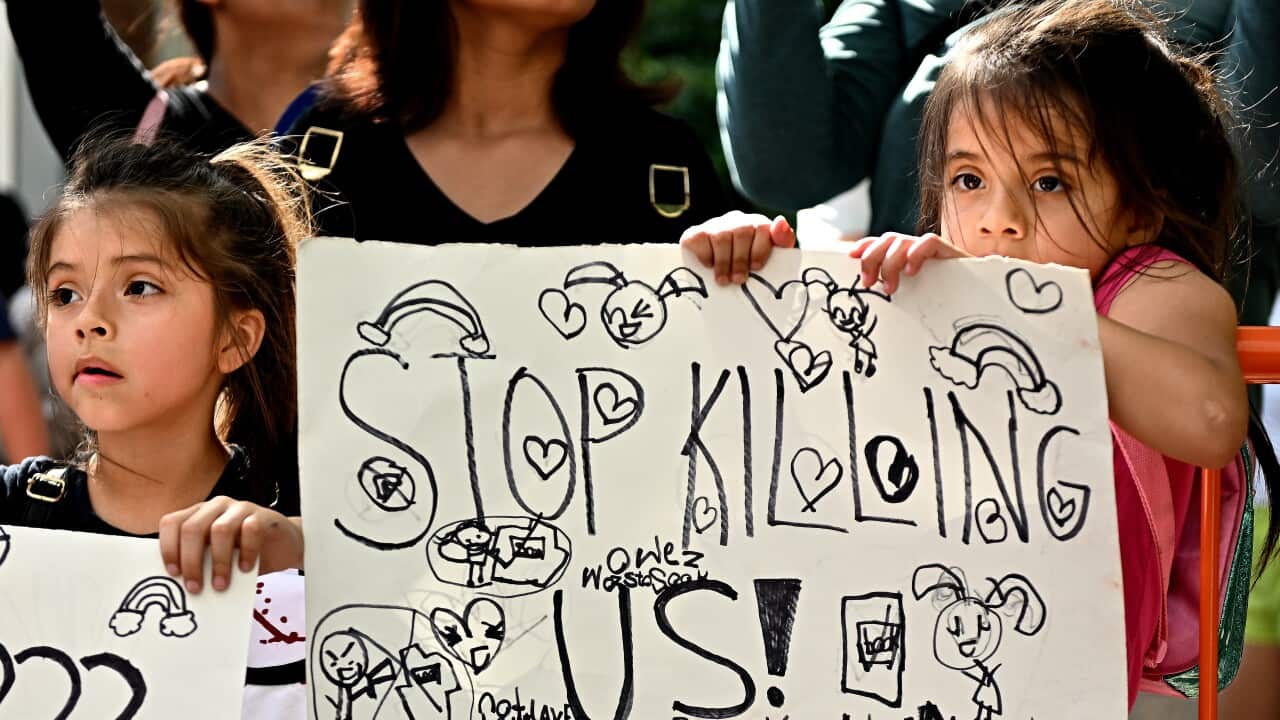 A young girl holds a sign during a protest outside the George R. Brown Convention Center in Houston Friday as the NRA Convention is held a few days after the Robb Elementary school shooting in Uvalde, Texas.