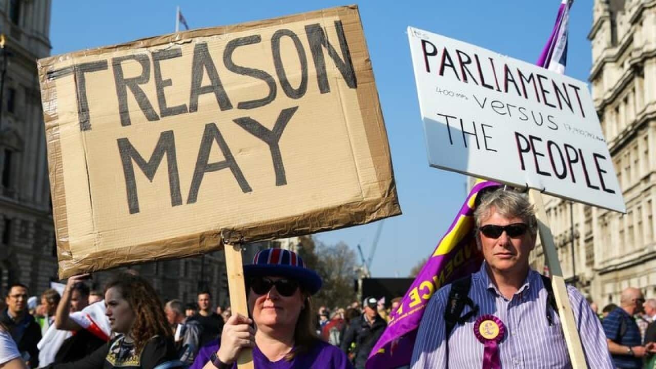 protesters are seen outside UK Houses of Parliament holding
