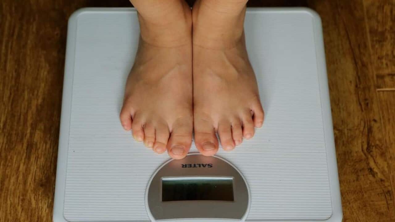 A young child being weighed on scales