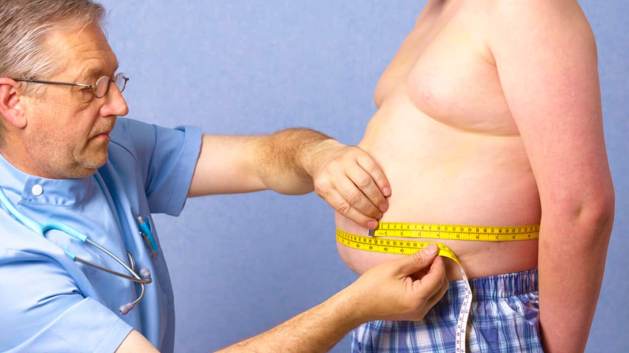 Senior doctor measuring 12 year old obese boy