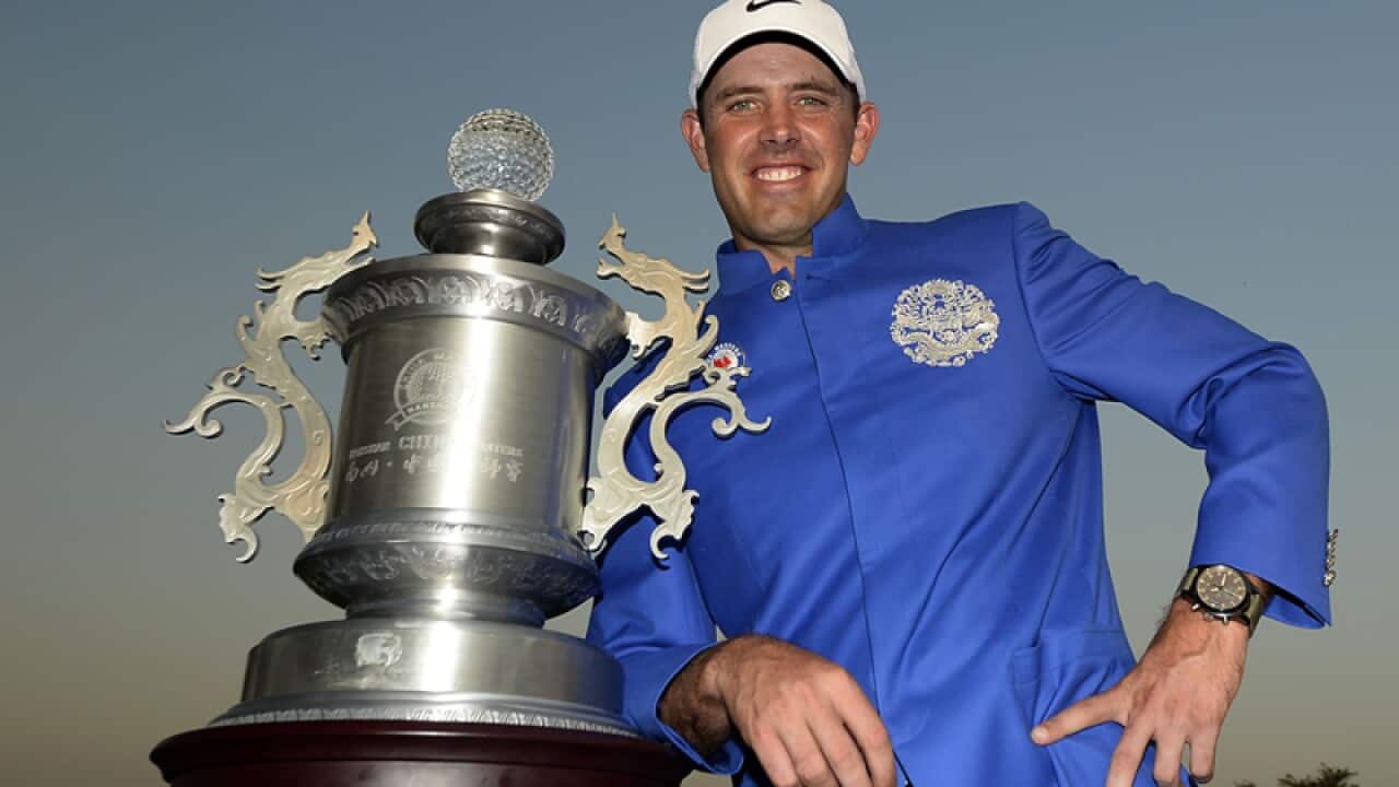 Charl Schwartzel of South Africa poses with the winner's trophy,China