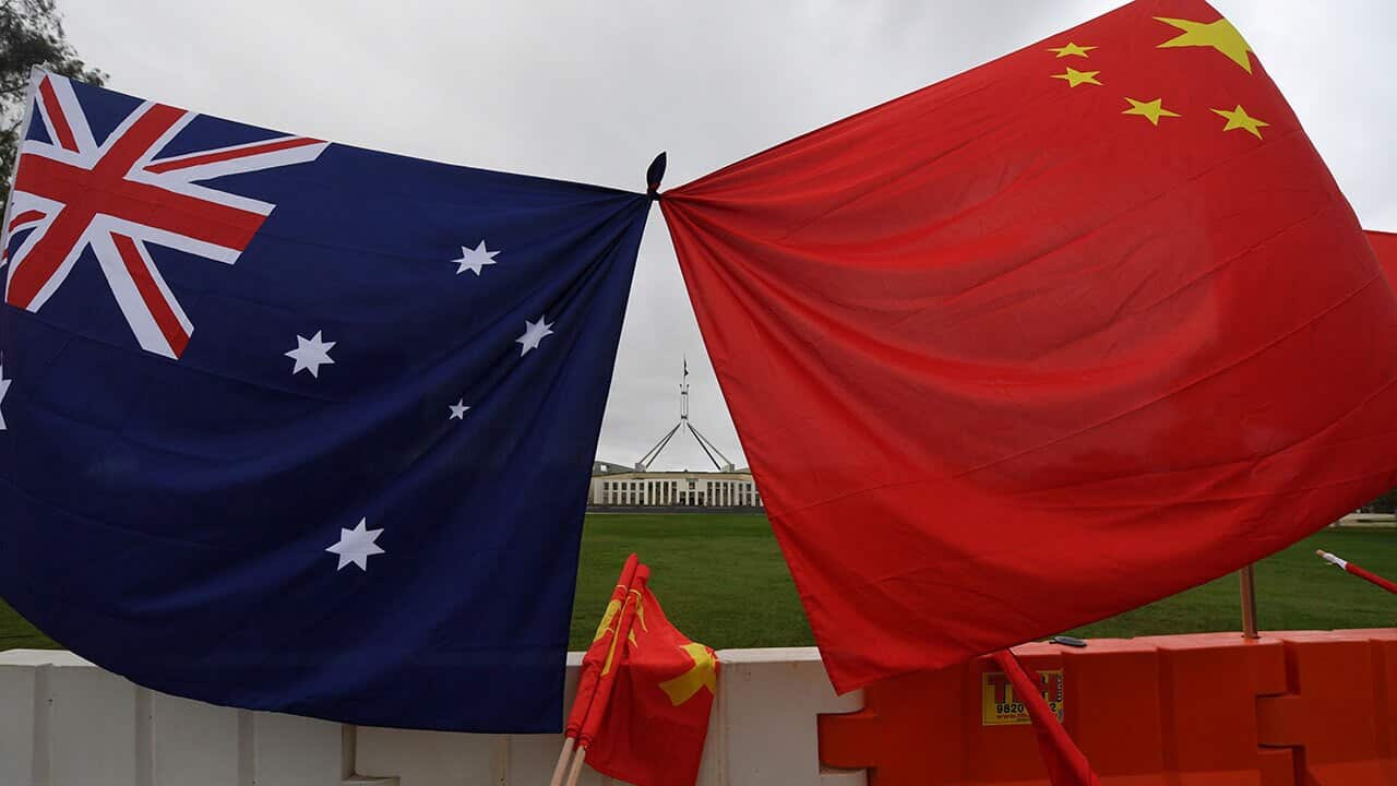 Australia's Parliament House is seen behind an Australian and a Chinese flag.