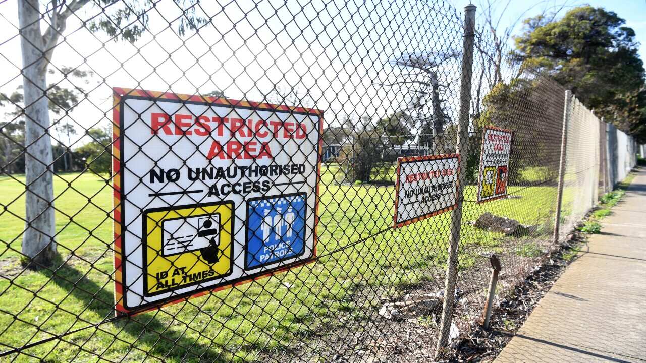 Signage is seen along the fence of the Melbourne Immigration Transit Accommodation complex in Broadmeadows, Melbourne.