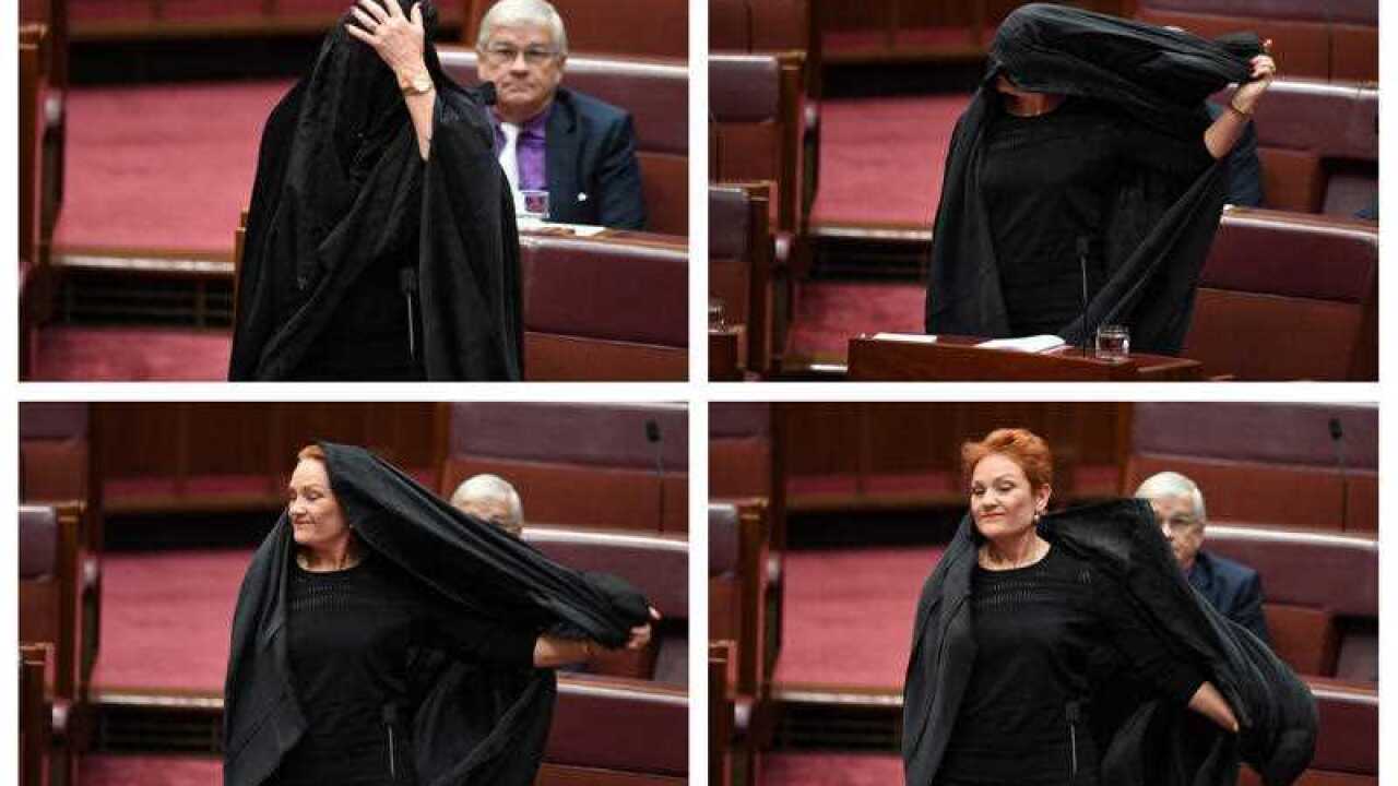 One Nation Senator Pauline Hanson takes off a burqa in the Senate.
