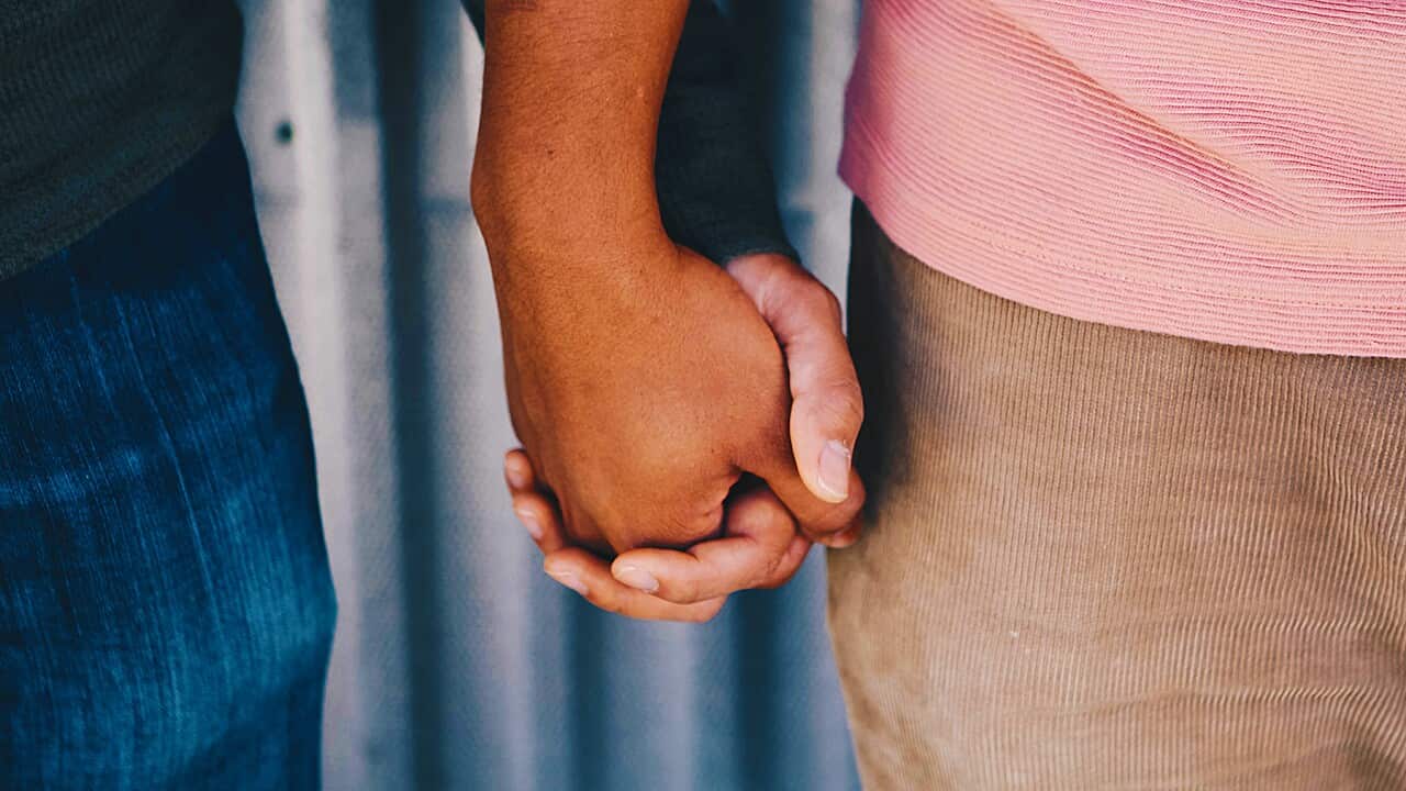 Image of two men holding hands