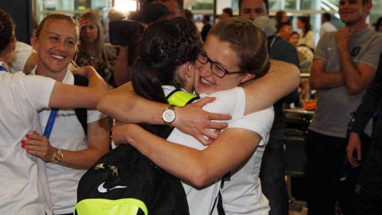 England's Ellen White hugs a team mate as they arrive back at Heathrow Airport after the 2015 FIFA Women's World Cup in Canada.