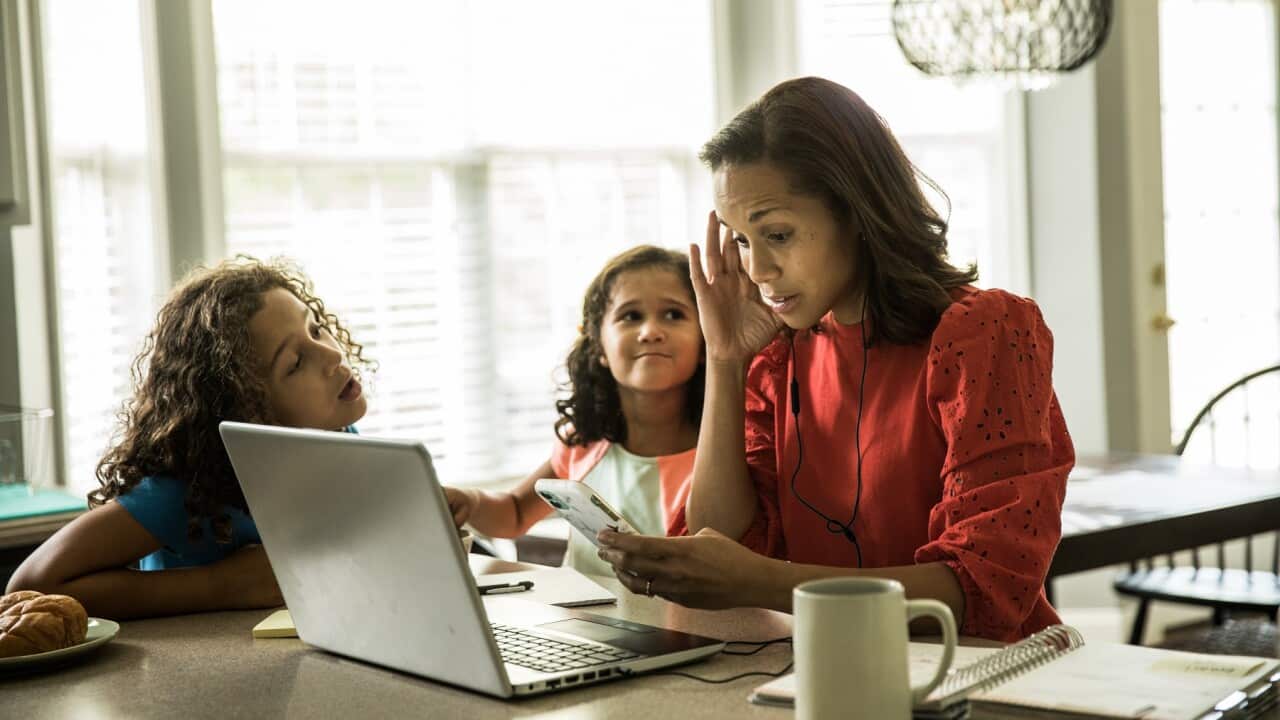 Mother working from home with children in background