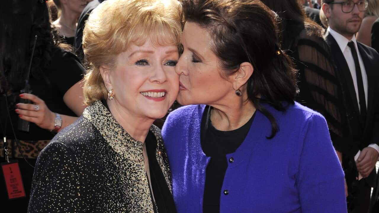 FILE- In this Sept. 10, 2011, file photo, Debbie Reynolds, left, and Carrie Fisher arrive at the Primetime Creative Arts Emmy Awards in Los Angeles. Reynolds, star of the 1952 classic "Singin' in the Rain"