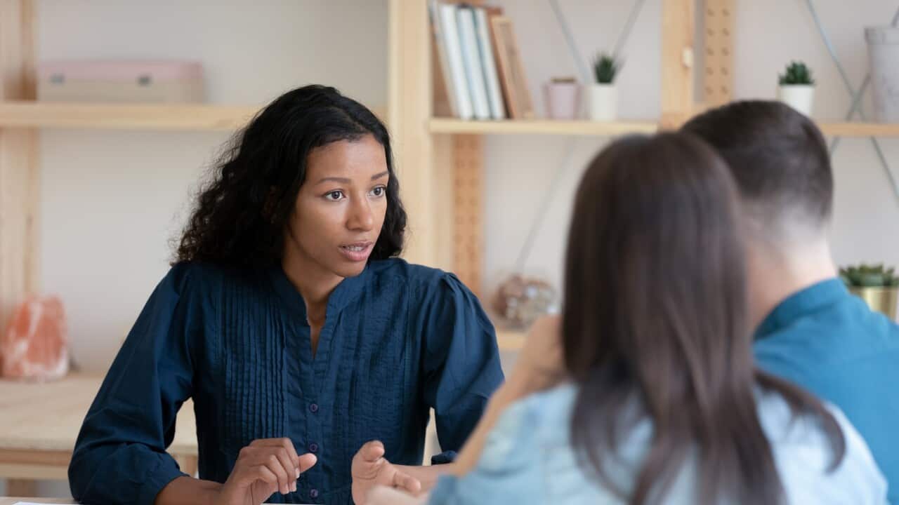 Female Real Estate Agent consult young couple at office meeting