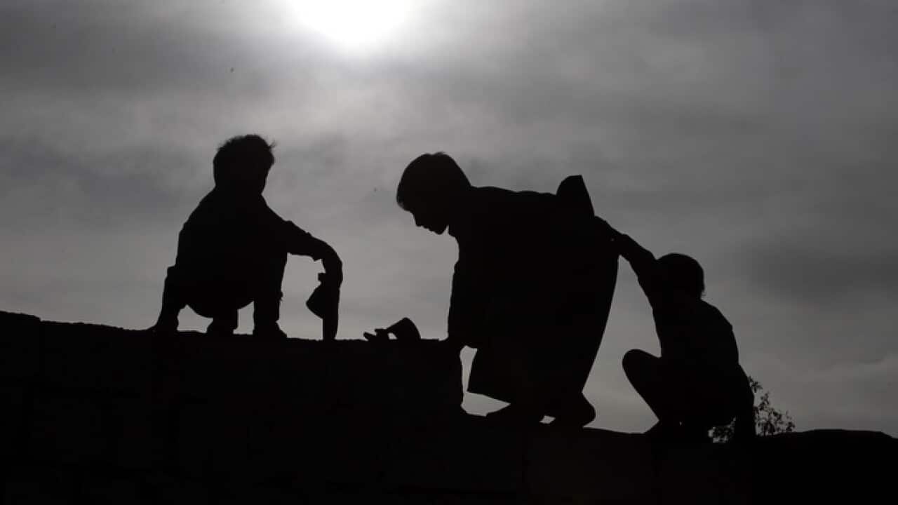 Watoto wakiYemeni watembea juu ya ukuta, katika maeneo ya nje ya mashariki ya mji wa Sanaâ, Yemen