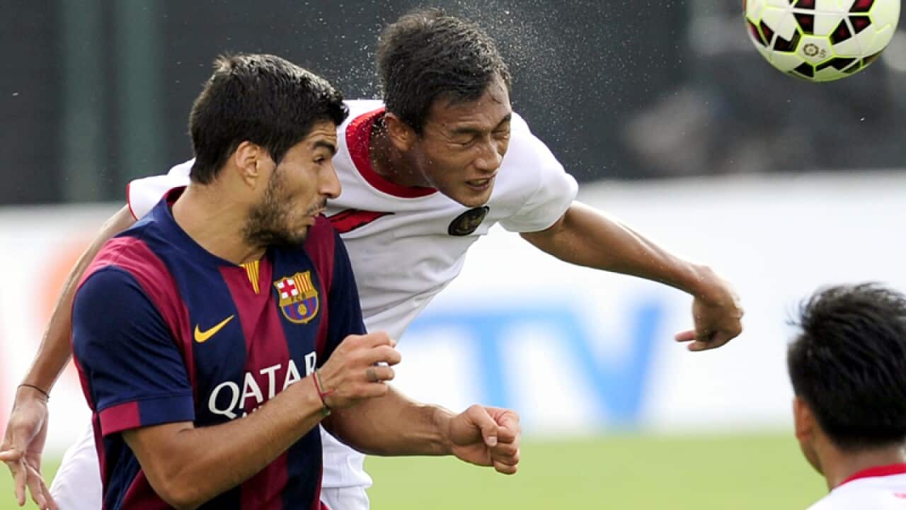 FC Barcelona's Luis Suarez (L) in action against Indonesia