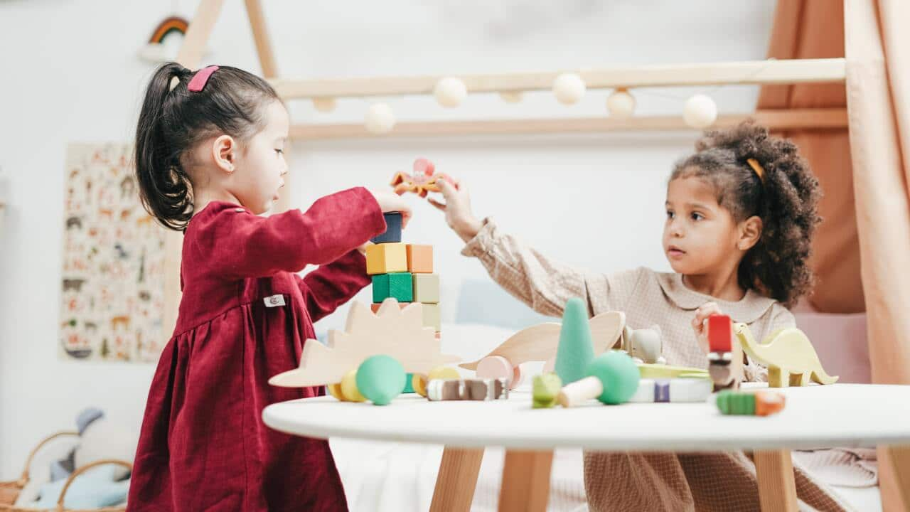 Girl in red dress playing with wooden blocks