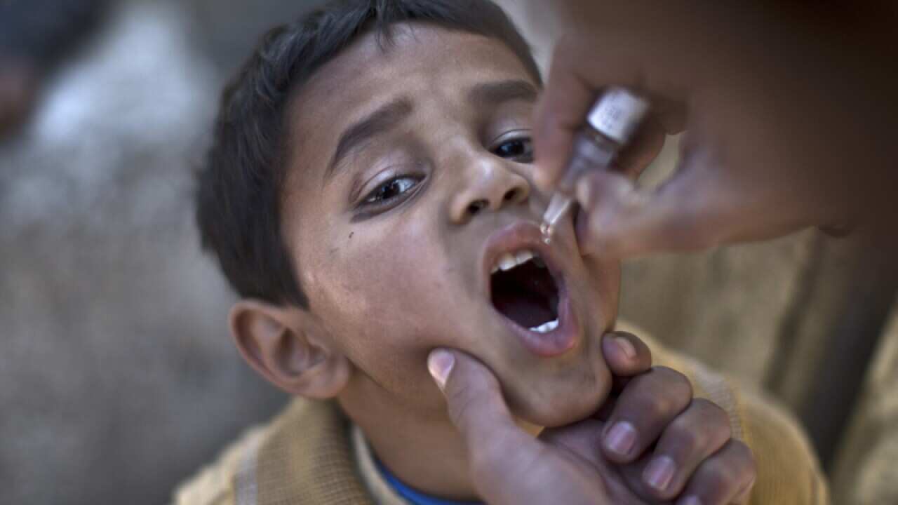 A Pakistani child is vaccinated against polio by a health worker.