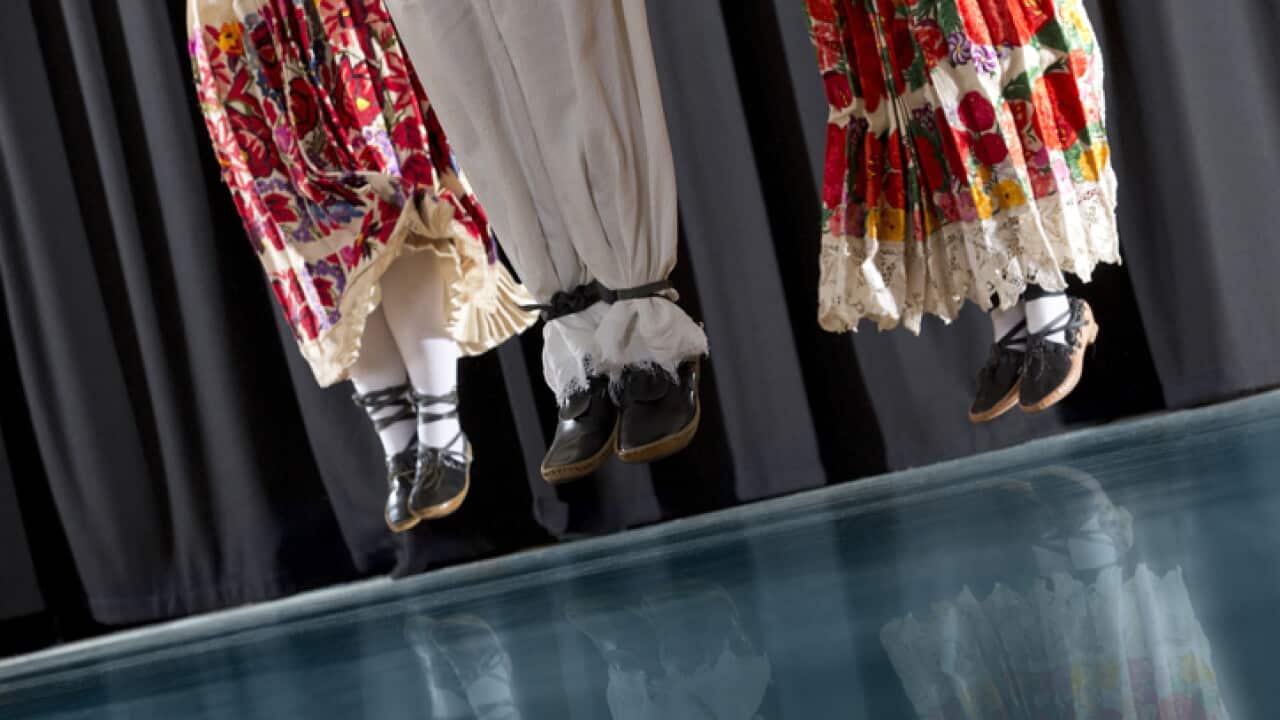 Traditional Croatian Folklore Dancers in action, short depth of field, reflection on blue floor