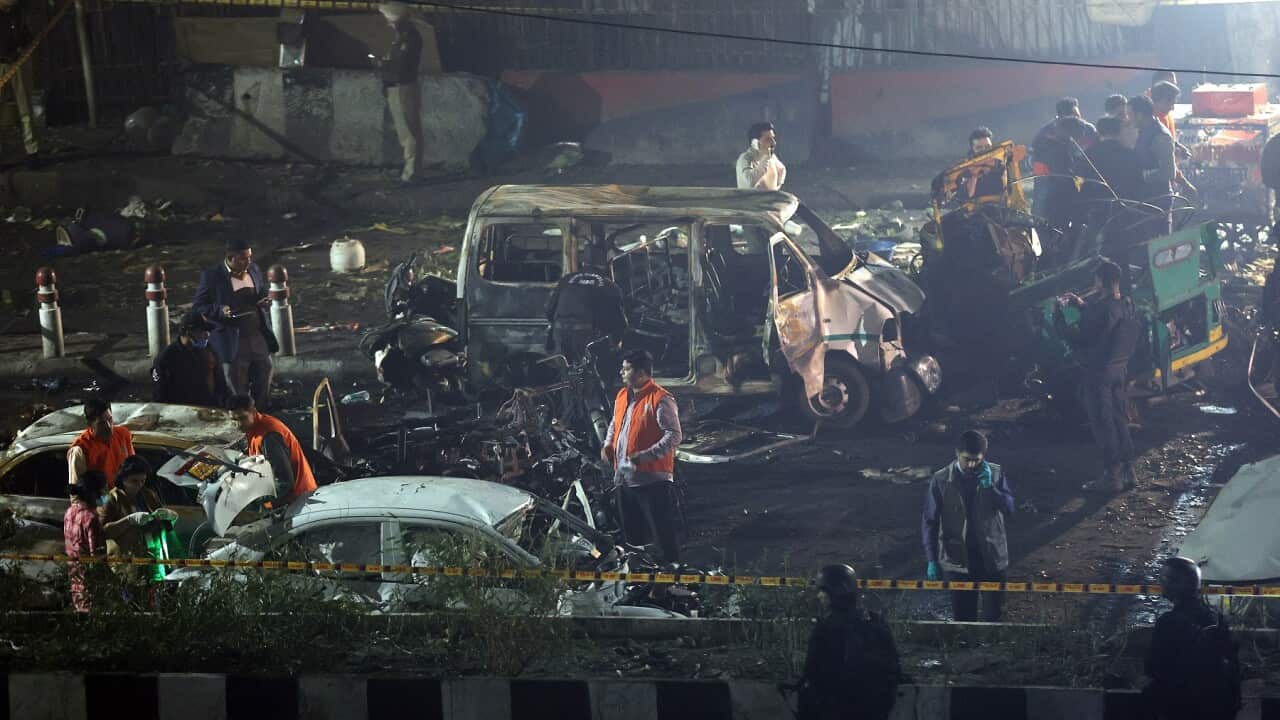 Indian police personnel inspect the scene of a blast near the red fort in New Delhi