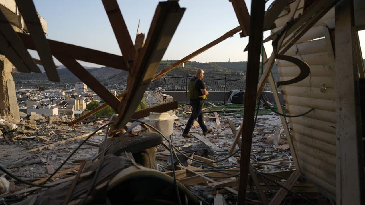 Israeli security forces survey damage to a home struck by a rocket fired from Lebanon in the town of Majd al-Krum.