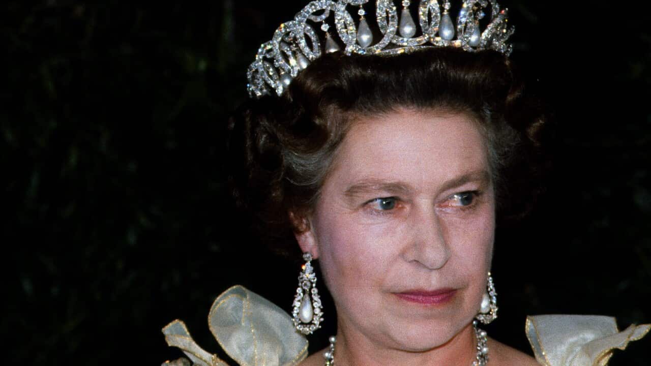 Nancy Reagan (left) and Queen Elizabeth II (wearing a tiara) standing next to each other.