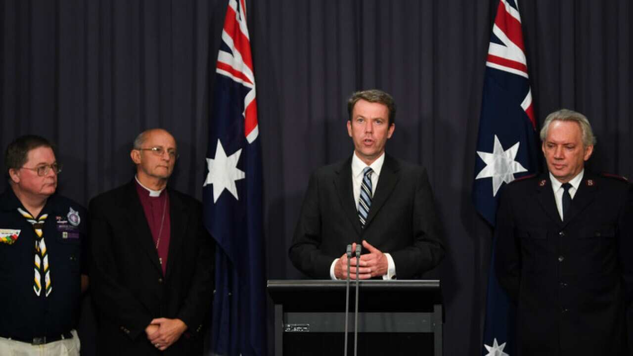 Australian Social Services Minister Dan Tehan and representatives of four non-government institutions speak during a press conference.