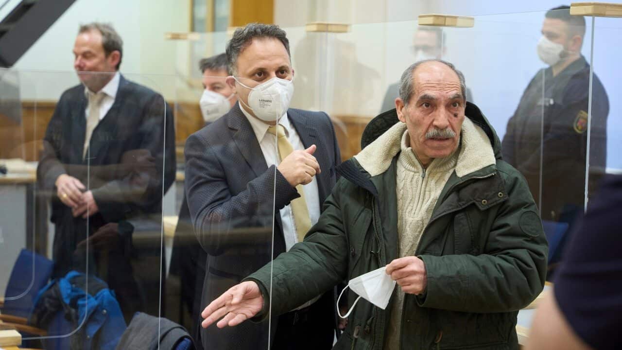 Anwar Raslan, right, stands in court before the pronouncement of the verdict