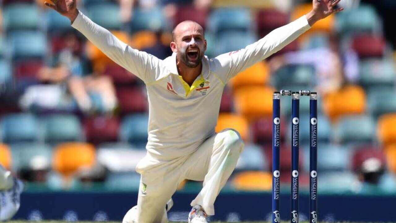 Nathan Lyon holding his arms up
