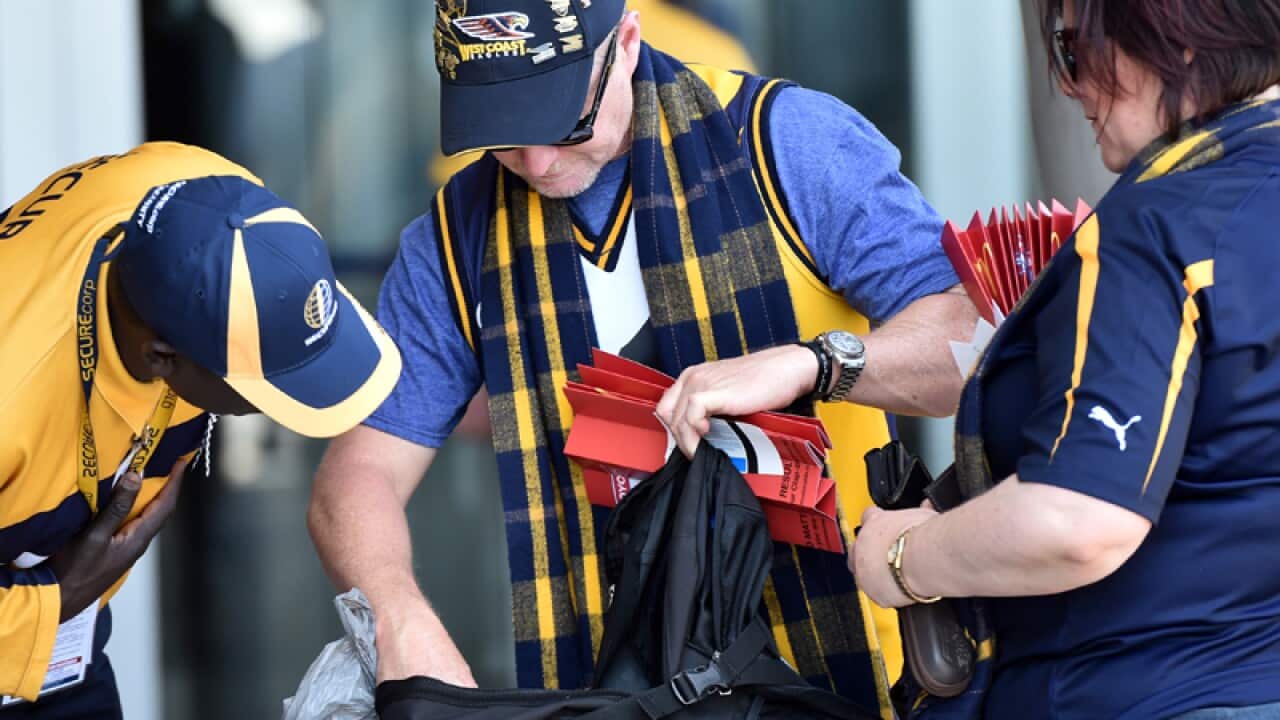 A security guards inspect the bags of West Coast Eagles fans
