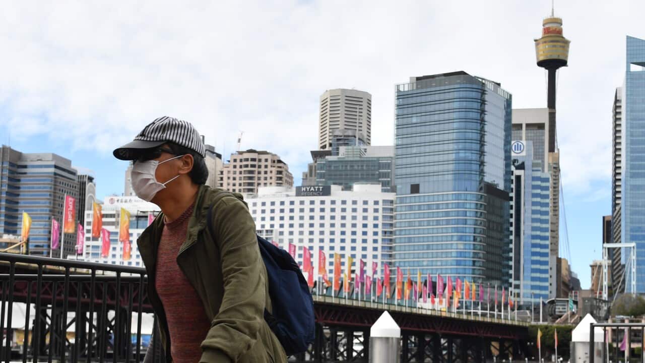 A pedestrian is seen wearing a face mask at Darling Harbour in Sydney.