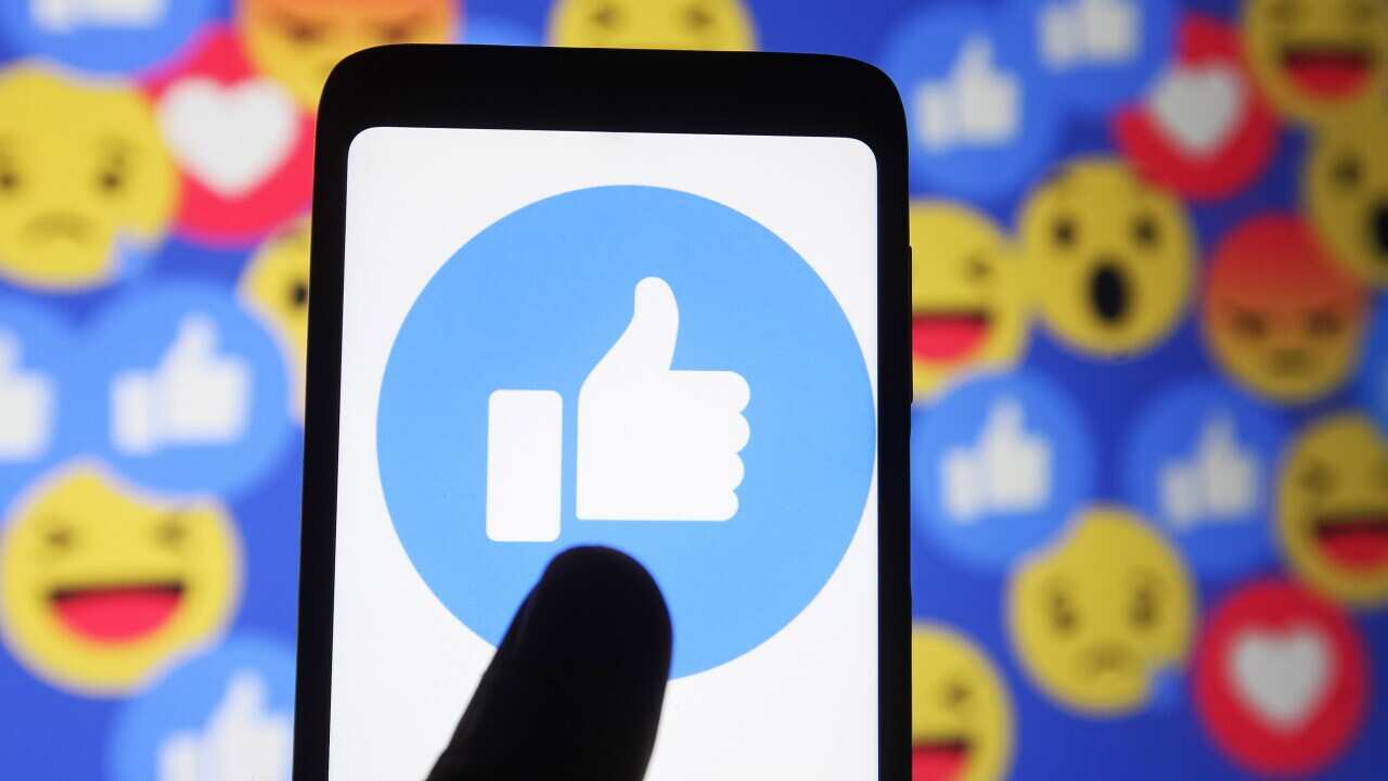 A photo illustration showing a thumbs-up sign emoji and smiley.