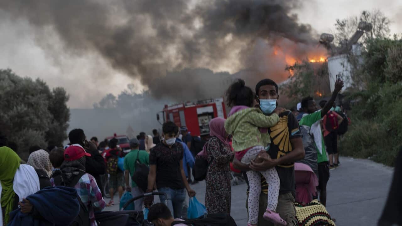 Migrants flee from the Moria refugee camp during the fire