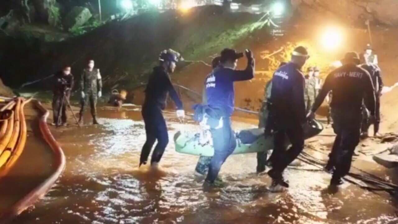 Rescue teams work to evacuate 12 boys and their football coach from a flooded cave in northern Thailand. 
