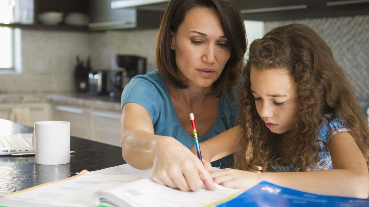 Woman helping daughter with her studies