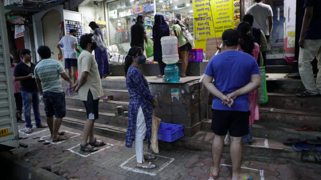 People queue at a shop while social distancing in Mumbai.