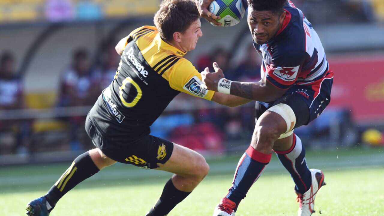 Amanaki Fafi of the Rebels runs past Beauden Barrett of the Hurricanes
