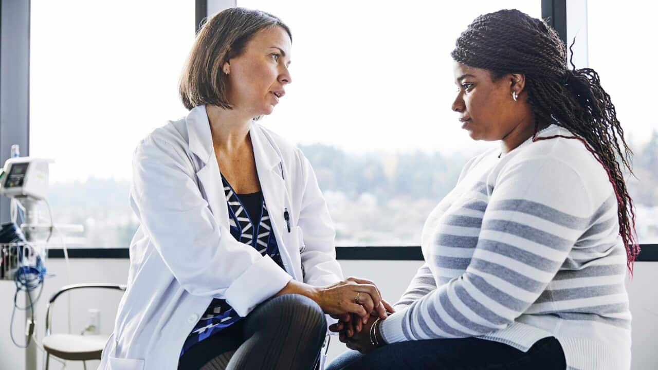 Doctor consoling female patient