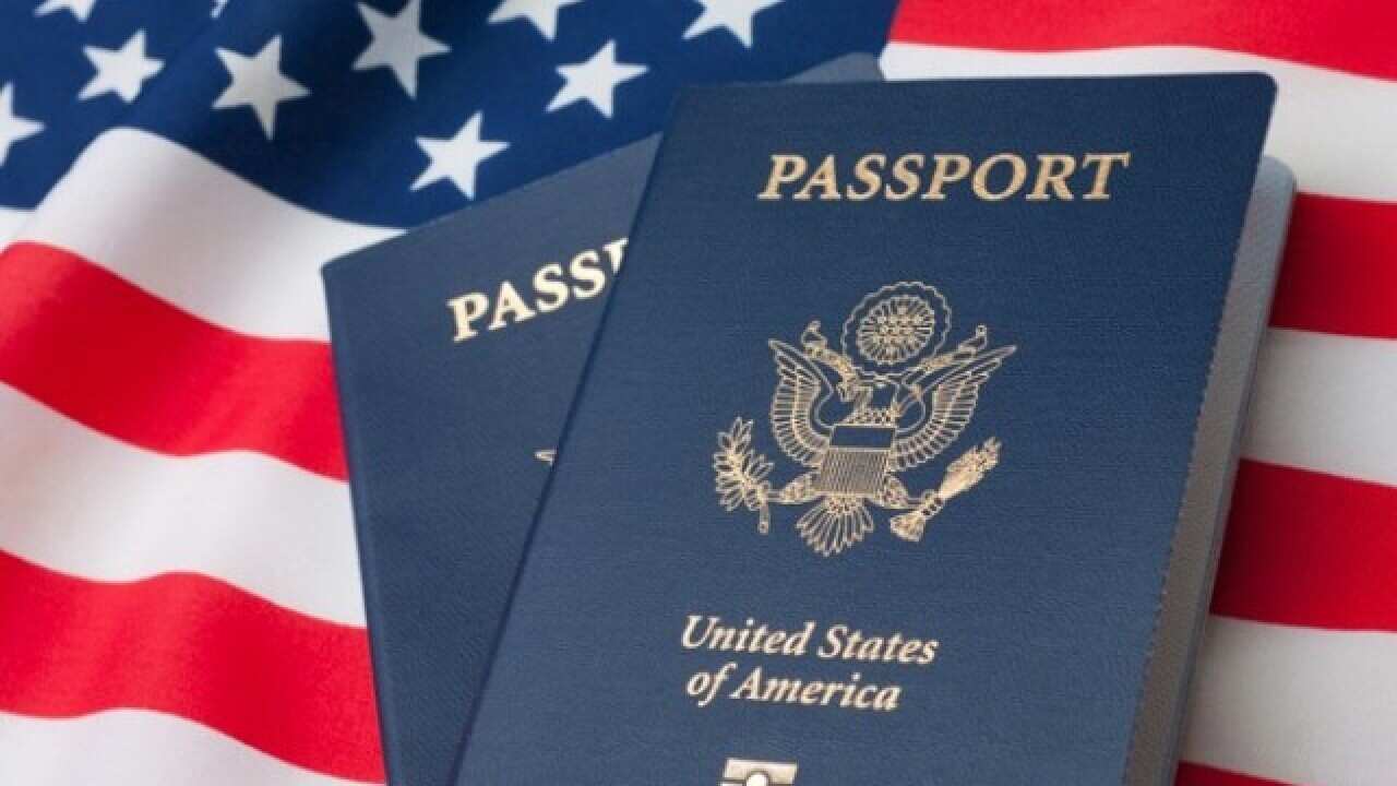 Two blue US passports, one laid on top of the other, on top of a US flag.