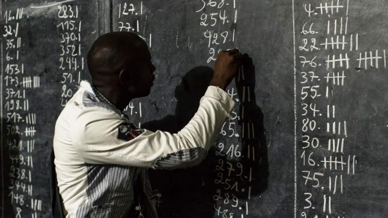 An election clerk counts votes at a polling station in Kinshasa, Democratic Republic of the Congo