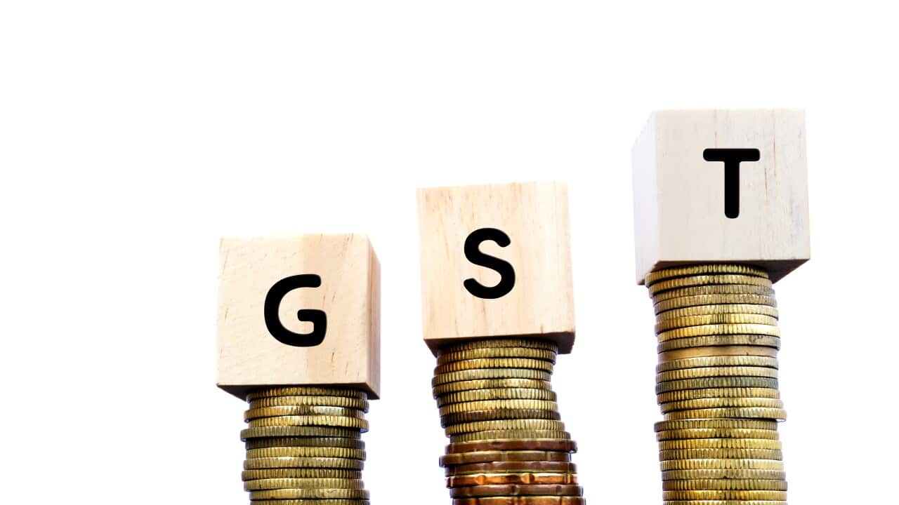 GST Word on Wood Block on Top of Coins Stack