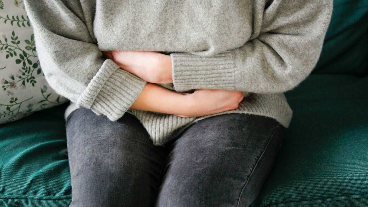 A woman in a grey jumper crossing her arms