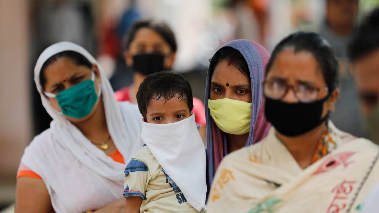 People wait in a queue to give their nasal swab samples to test for COVID-19 in Prayagraj, India, Saturday, Sept. 5, 2020.
