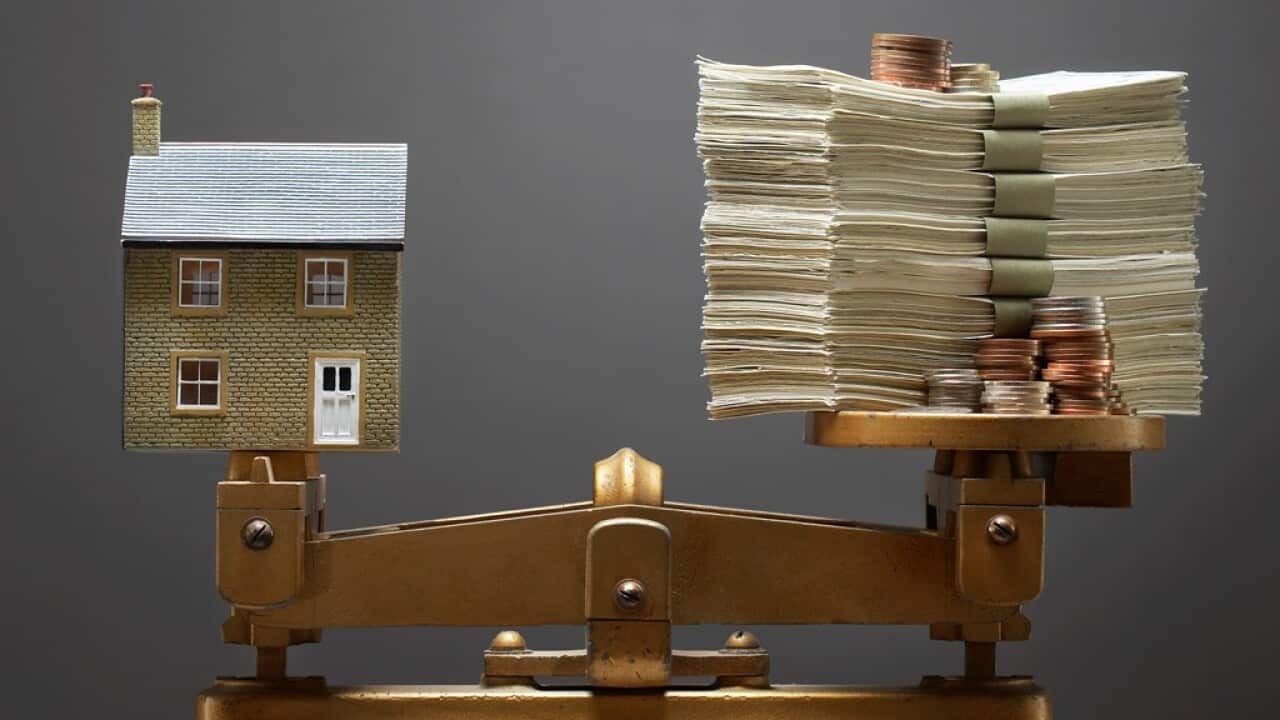 Model house and money on scales