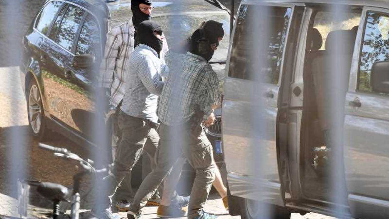 A terrorism suspect, second right, is led away at the German Federal Court of Justice in Karlsruhe, Germany