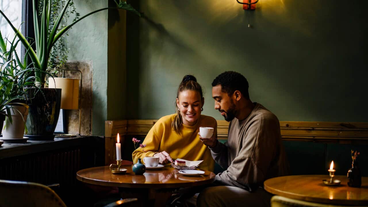 Wide shot with copy space of couple sharing a dessert in cafe