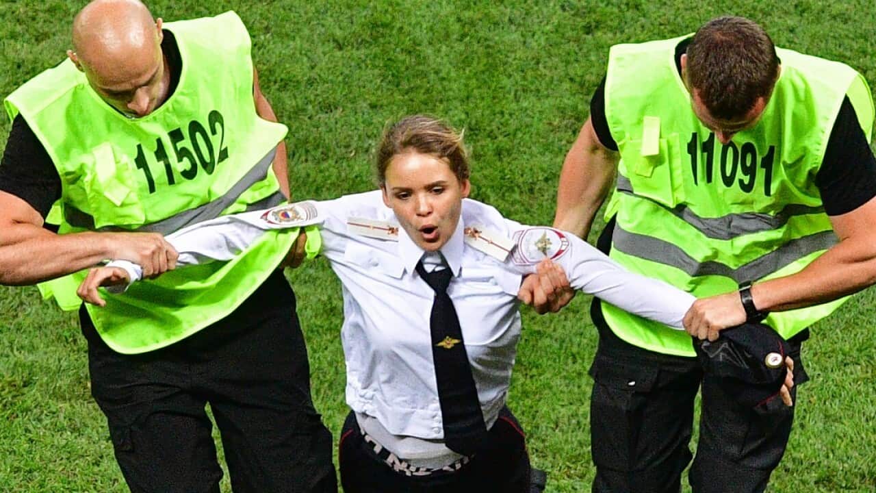 A member of Pussy Riot is escorted by stewards during the Russia 2018 World Cup final.