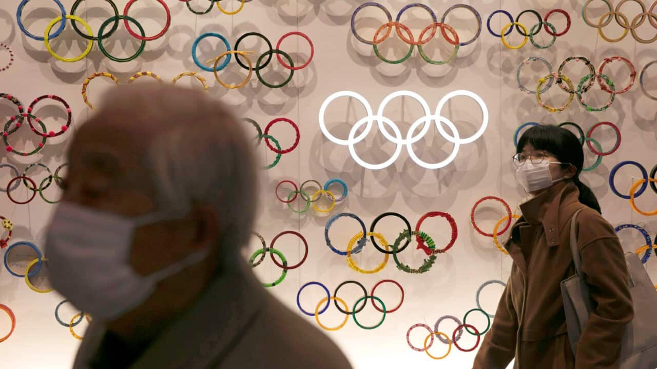 Two people wear masks as they visit the newly opened Japan Olympic Museum