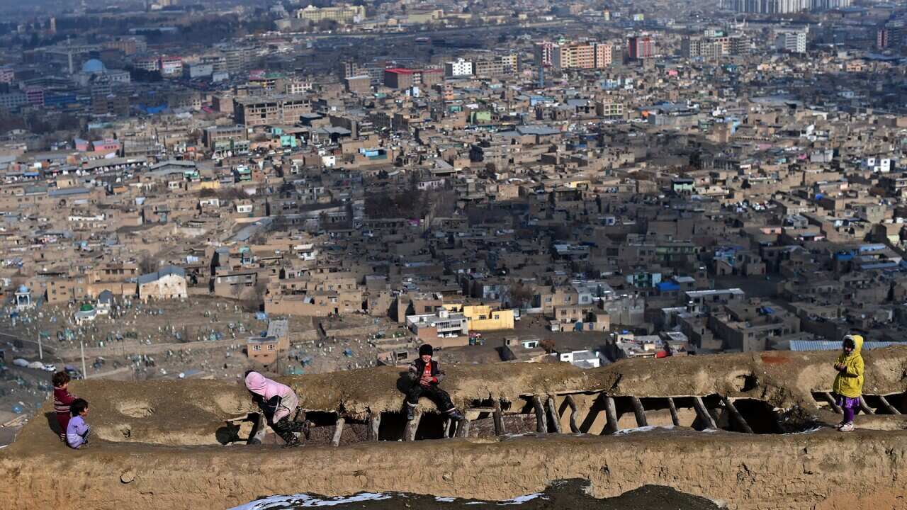 Afghan children play on a damaged rooftop overlooking Kabul on January 24, 2015.